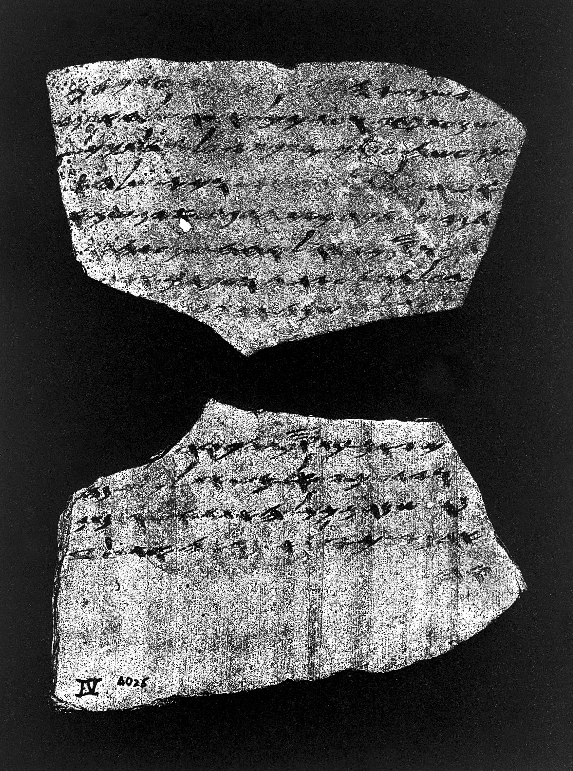 Black-and-white photograph of both sides of Lachish Letter 4, showing lines of dark Hebrew ink on an irregular pottery fragment.